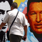A man in Caracas walks past a mural featuring Simon Bolivar and Hugo Chavez Photo: CNN