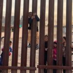 Children play by the fence on the Mexican side of the US-Mexico border